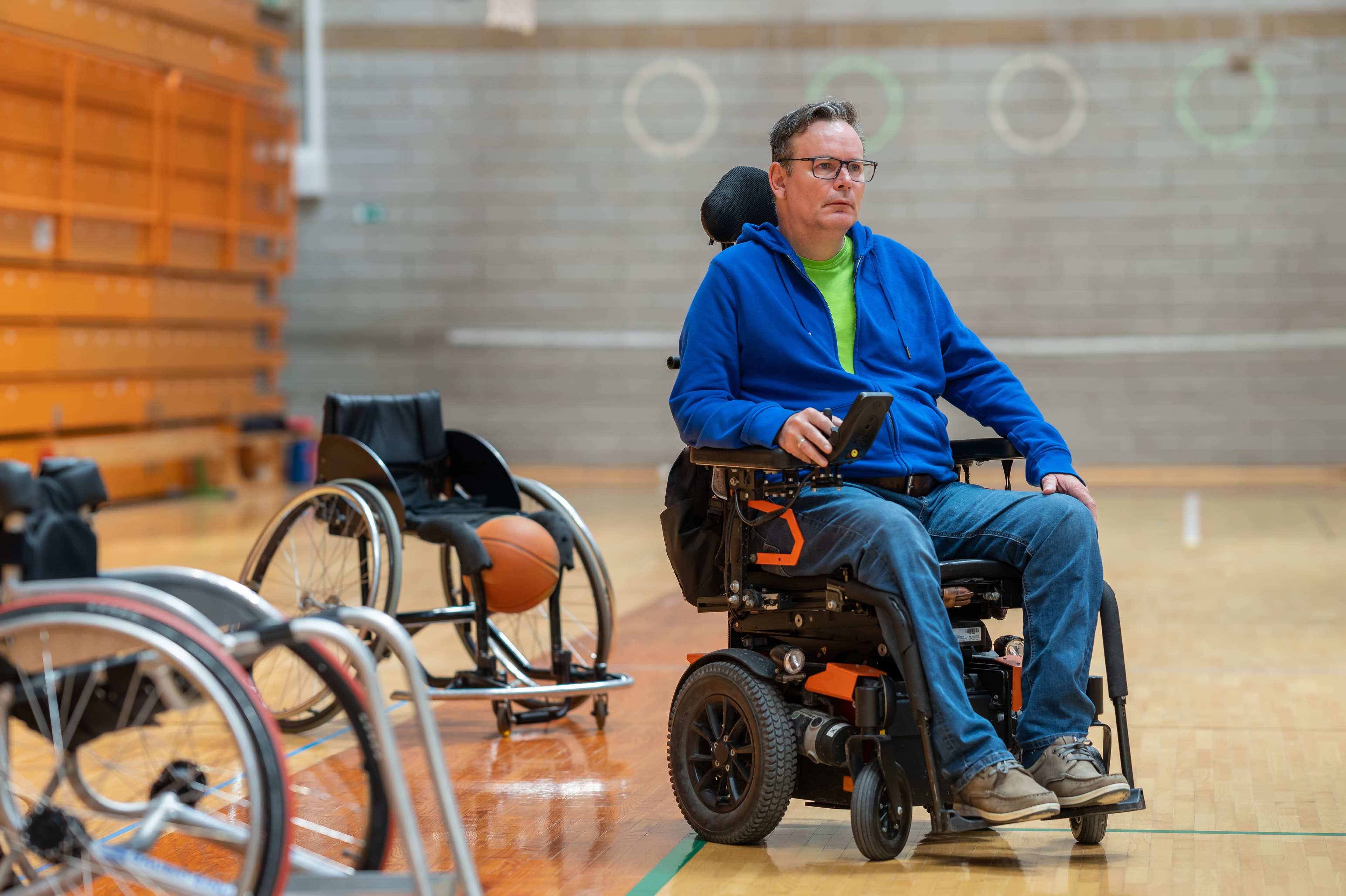 Person in wheelchair in basketball court showing independence and active lifestyle